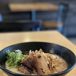 a bowl of ramen with meat and vegetables