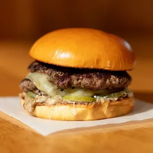 a hamburger with cheese and pickles