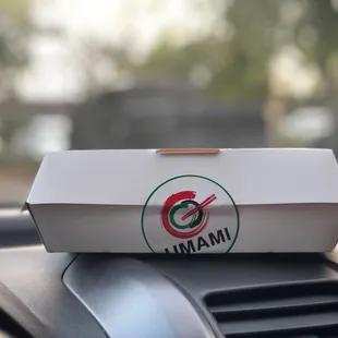 a box of food on the dashboard of a car