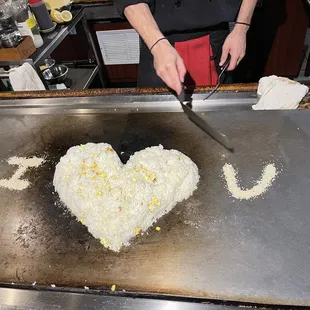 a person cutting a heart shaped cake