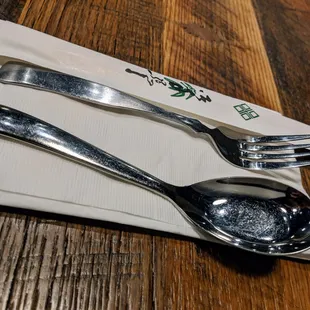 two spoons and a fork on a napkin