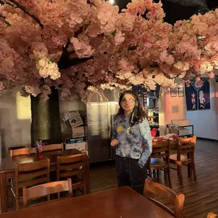 a woman standing under a cherry tree