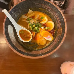 a person holding a bowl of ramen