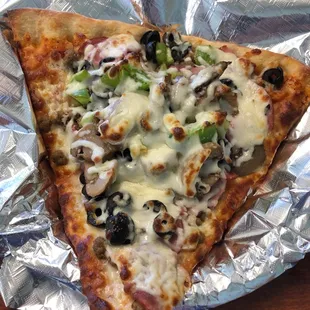 a slice of pizza on aluminum foil