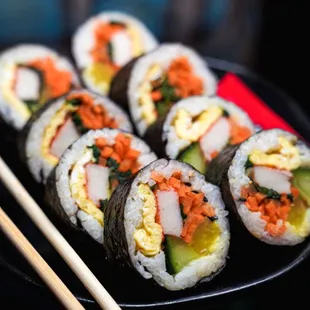 a plate of sushi and chopsticks