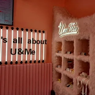 a pink wall with neon signs