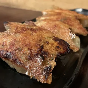 two pieces of meat on a black plate