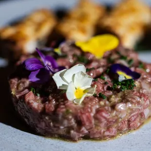 a plate of food with meat and flowers