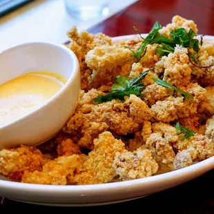 Popcorn Chicken: deep fried marinated chicken coated with potato flour, served with house made mayo sauce and deep-fried basil ($10).