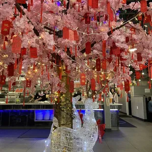 a cherry blossom tree with red paper lanterns hanging from it