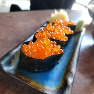 a plate of sushi topped with cavia