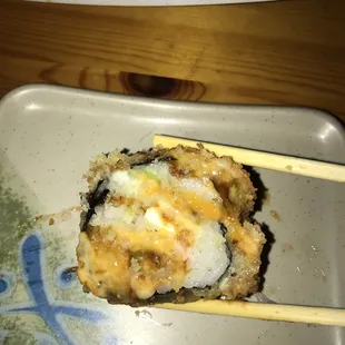 a close up of a sushi with chopsticks