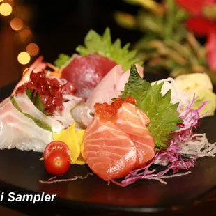 sashimi sampler on a black plate