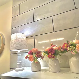 three vases of flowers on a counter