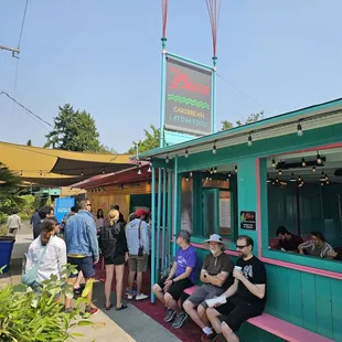 a group of people sitting outside of a restaurant