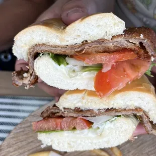 a person holding a sandwich and french fries