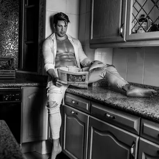 a shirtless man in a kitchen