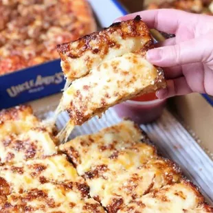 a hand holding a slice of pizza
