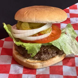 a hamburger with lettuce, tomato, onion, and pickles