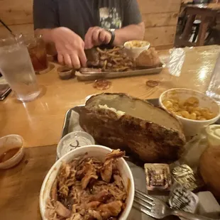 ows a man sitting at a table with a plate of food