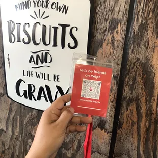 a hand holding a sign that says, mind your own biscuits and the will be grand