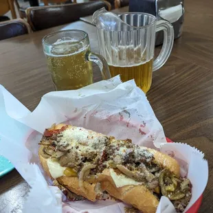 Small pitcher and a steak sub w onions, peppers mushrooms and cheese and toasted in the pizza oven.