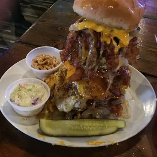 a burger with bacon, cheese, and pickles