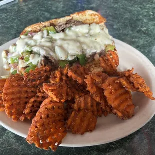 Philly cheesesteak sandwich and sweet potato fries