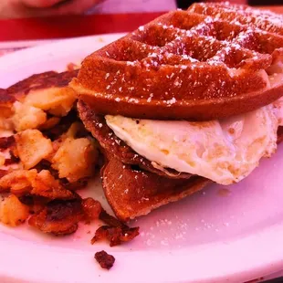 a waffle sandwich with eggs and bacon
