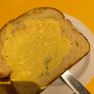 a slice of bread on a plate with a knife