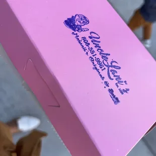 a hand holding a pink box