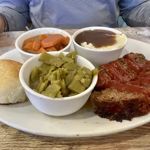 Meat and three. Meatloaf, green beans, carrots mashed potatoes with gravy and a roll.