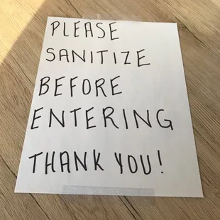 Sign asking patrons to sanitize