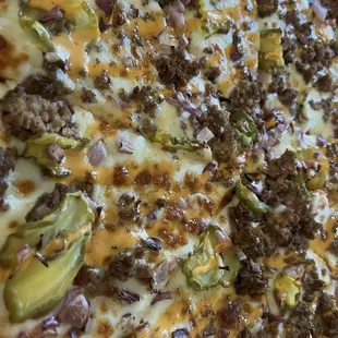 a pizza with meat, cheese, and vegetables