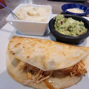 Lunch menu quesadilla with a side of guac and Mexican mashed potatoes.