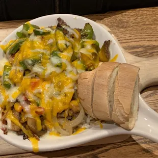 Beef tips with vegetables rice, topped with cheese.