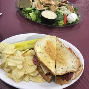Chicken Caesar salad and Reuben with chips.