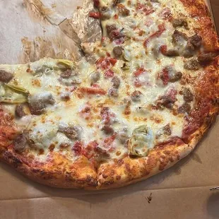 Rustic pizza with sausage, peppers, artichoke hearts