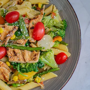 a plate of pasta with chicken and vegetables