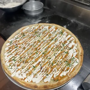 a pizza with sauce drizzled on it