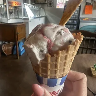 a hand holding a cone of ice cream