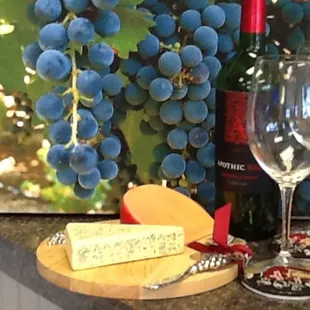 a glass of wine, cheese and grapes