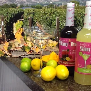 bottles of wine, lemons, and limes on a counter