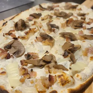 a mushroom and cheese pizza on a cutting board