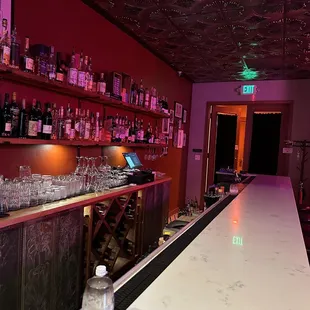 The bar and the door to the hallway to the bathroom is at the end