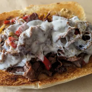 Cheesesteak! Roast beef, red peppers, peperoncinis, caramelized onions, stone-ground mustard &amp; provolone cheese.
