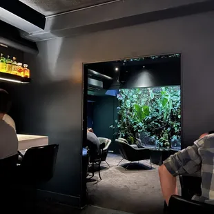 a man sitting in front of a fish tank
