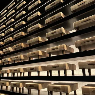 rows of wooden benches lined up against a wall