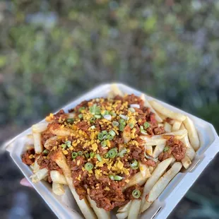 a hand holding a container of food