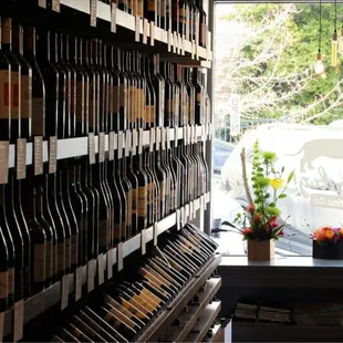 a man standing in front of a wall of wine bottles